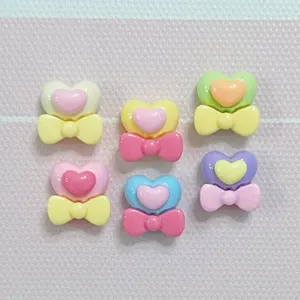 Close-up detail of colorful resin heart bow charms, perfect for DIY nail art and crafts.