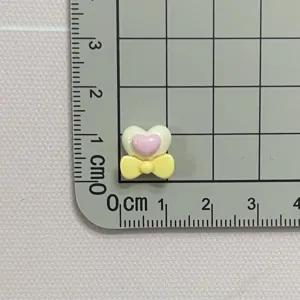 Mini solid color resin heart and bow shape detail for nail art crafts and DIY hair clips.