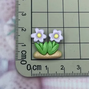 Resin flower cabochon detail view showing size on grid mat for DIY crafts and phone cases.