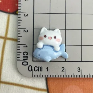 Primo piano dettagliato di un ciondolo in resina gatto e balena blu per creazioni fai da te.