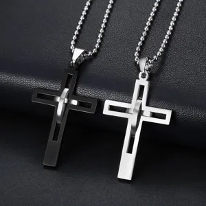 Colliers avec pendentif croix en acier titane noir et argenté sur fond en cuir sombre.