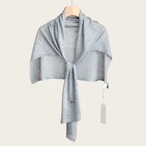 Close-up detail of the lightweight grey knitted shawl, showing fine knit texture and T-shape style.