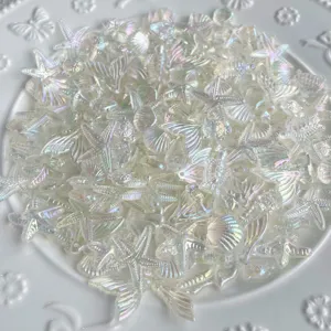 Vue rapprochée de breloques marines en résine iridescente, coquillages et étoiles de mer.