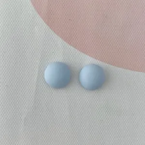 Primo piano di piccoli cabochon in resina azzurra, perfetti per fai da te e decorazioni per unghie.