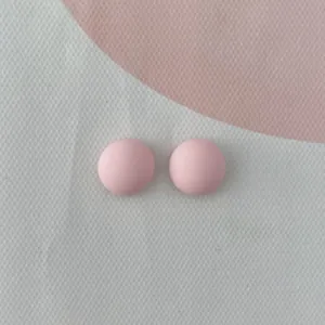 Primo piano di mini cabochon in resina rosa, ideali per nail art e decorazione custodia telefono.
