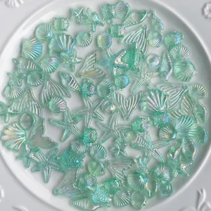 Vue detaillee de cabochons en resine motif ocean irise, perles coquillage etoile de mer pour art.
