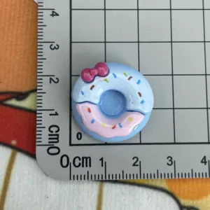 Cabochon ciambella resina blu con fiocco rosa e zuccherini, vista dettaglio decorazione.