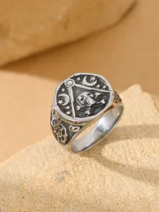Close-up of a vintage stainless steel ring featuring skull, crossbones and crescent moon details
