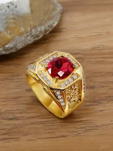 Macro view of gold-plated stainless steel men's ring with a vibrant red gemstone