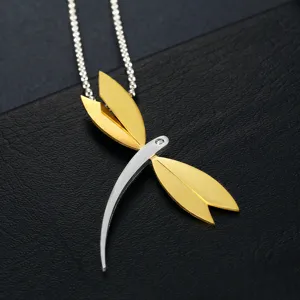 Close-up of elegant dragonfly pendant in two-tone stainless steel with crystal