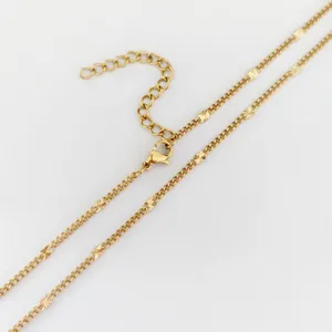 Close-up of gold stainless steel star disc chain detail with lobster clasp and extension.