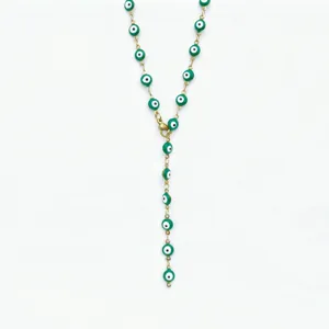 Stainless steel green evil eye Y necklace detail, gold tone chain link closeup, fashion jewelry.