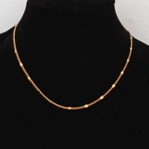 Gold chain necklace detail view, minimalist stainless steel clavicle chain link texture.