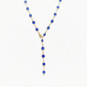 Detailed view of stainless steel gold-tone Y-chain necklace with blue glass stones.