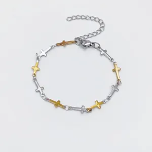 Close-up view of stainless steel cross bracelet with dual tone metal links and clasp.