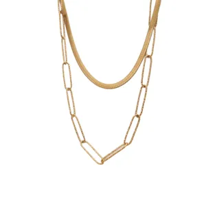 Collana multistrato dorata con catena a spina di pesce e design a graffetta chic.