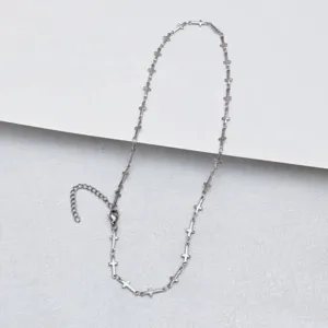 Stainless steel cross necklace detail, stylish chain with tiny cross charms for daily wear.