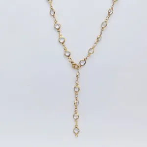 Detailed view of gold stainless steel Y-shaped necklace sparkling clear glass stones bohemian style.