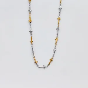 Detail view of two-tone stainless steel cross chain necklace with gold and silver crosses.