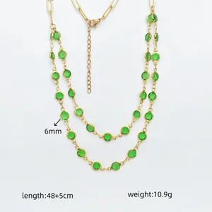 Detailed view of double layer gold stainless steel necklace with green round crystal bezels.