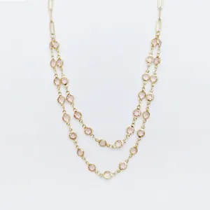 Close-up of double layer stainless steel necklace with pink bezel-set crystal stones.