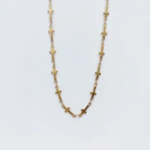 Gold stainless steel cross necklace detail, delicate chain with multiple small cross charms.