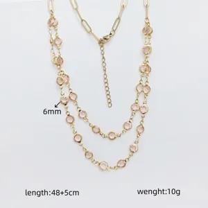 Double layer stainless steel necklace detail featuring sparkling pink crystal stones and gold chain.