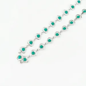 Close-up detail view of stylish stainless steel green heart chain link necklace jewelry.