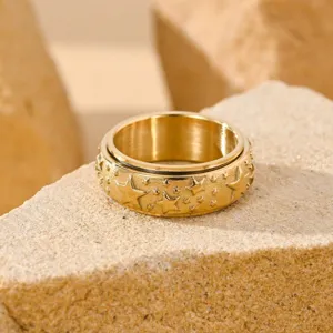 Vintage gold star spinner ring for men with unique relief design on stone background