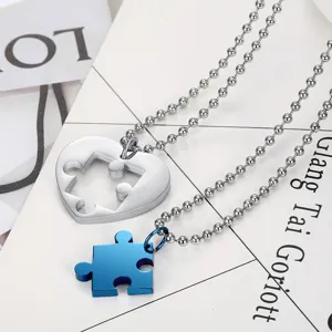 Detailed macro view of a stainless steel heart and puzzle piece couple necklace set
