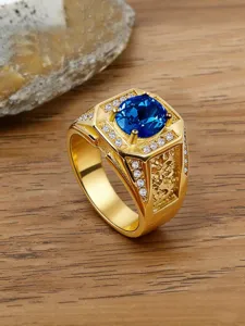 Close-up of vintage engraved men's gold ring with a large blue zircon gemstone