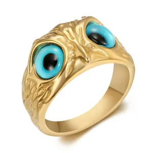 Detailed close-up of vintage gold owl eye stainless steel ring with blue eyes and punk style
