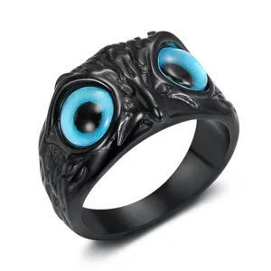 Detailed macro view showing the intricate carving and vivid blue eyes of the gothic owl ring.