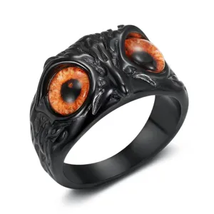 Close-up view of gothic owl eye ring with orange resin stones and black texture.