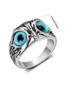 Close-up detail of a vintage stainless steel owl eye ring with vibrant blue pupils