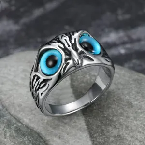 Detailed close-up of a vintage stainless steel owl ring featuring vibrant blue eyes