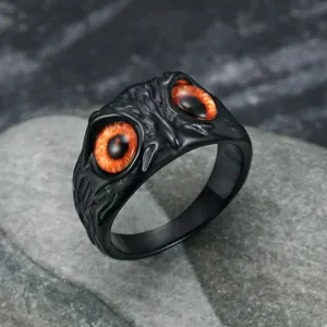 Detailed macro of vintage black owl eye ring with orange pupils in punk gothic style