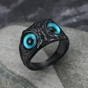 Detailed macro view of vibrant blue owl eyes on a vintage black punk stainless steel ring