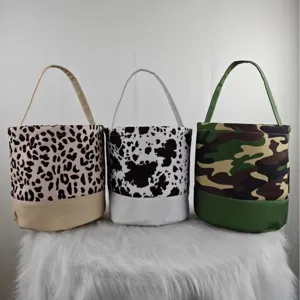 Three patterned canvas Halloween candy buckets in leopard, cow, and camouflage print designs.