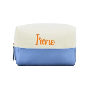 Detail einer Kosmetiktasche aus Segeltuch und blauem Leder mit orangefarbenem Namen