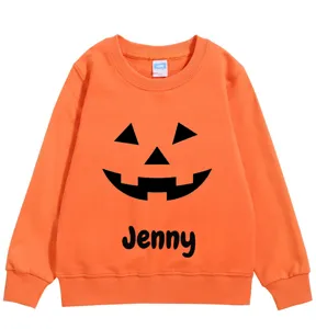 Detailed view of custom Jack-o'-lantern pattern and name on orange kids sweatshirt