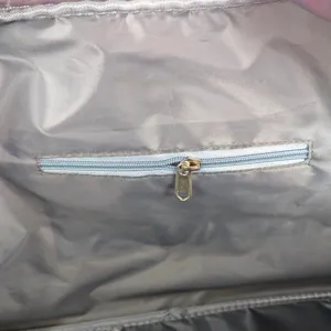 Detailed view of the interior lining and zipper pocket with a golden pull in a travel bag