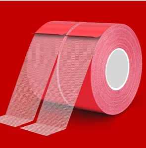 Close-up view of red heavy-duty double-sided mesh tape showing white grid texture
