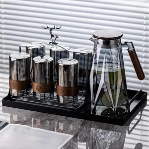 Smoked gray heat-resistant glass tea set with wooden insulation sleeves and deer rack