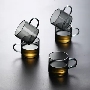 Set of high-quality heat-resistant smoky grey glass tea cups with handles on dark surface