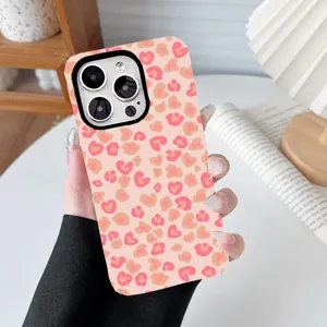 Close-up of pink heart leopard print phone case held in hand against a soft background