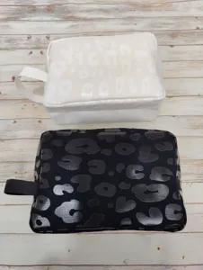 Detail showing black and white leopard print cosmetic bags with a glossy finish texture