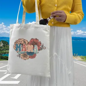 Detailed view of the MAMA floral print on a durable white canvas tote shopping bag