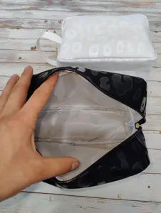 Internal detail showing the white lining interior of a large leopard print makeup bag
