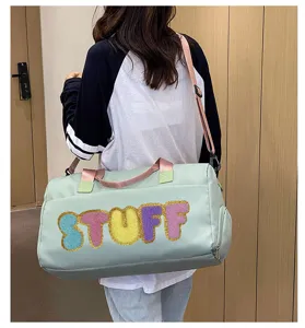 Model carrying a mint green sports gym bag with colorful fuzzy STUFF lettering decoration